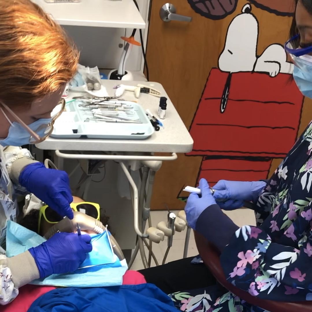 Pediatric dental team performing a gentle childrens cleaning exam